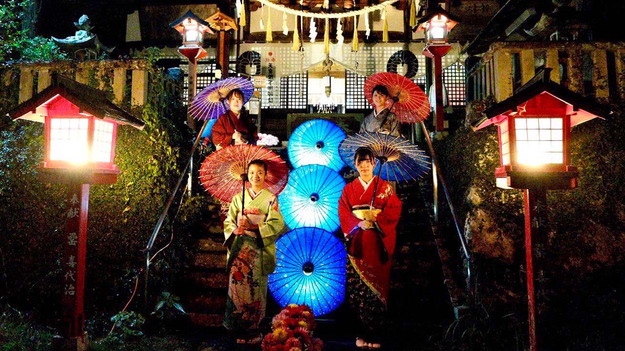 小鹿神社の和傘のライトアップで、和傘を持って階段に並ぶ女性