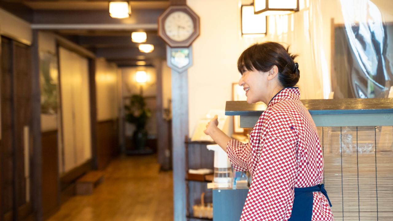 須崎旅館の女将の須崎真紀子がお客様に対応するおもてなしの場面